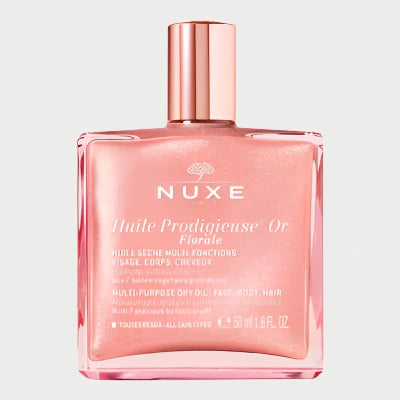 A luxurious dry oil for face, body, and hair, NUXE's Florale Dry Body Oil comes in a square rose gold bottle with French text on the label and is elegantly topped with a metallic pink cap.