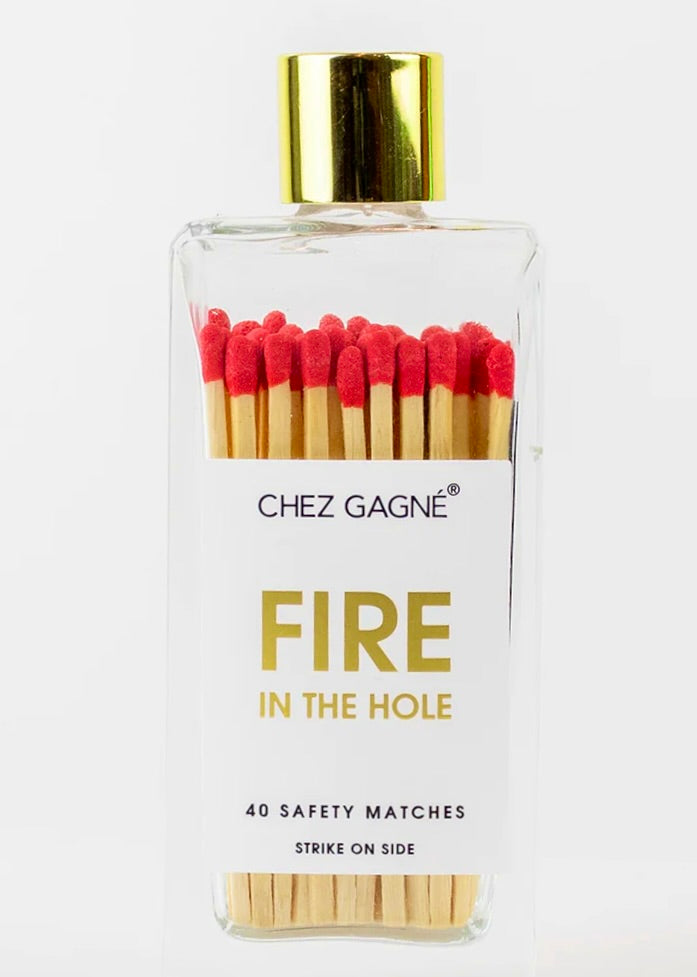 A transparent bottle labeled with the brand "Chez Gagné" contains 40 colorful matches, each with a red tip. These wooden matches are neatly arranged inside and the bottle is topped with a gold cap.