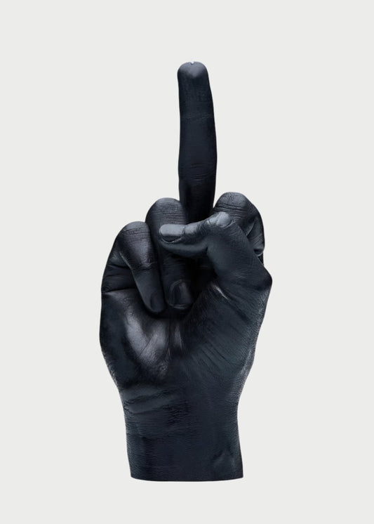 A black candle shaped like a human hand making an offensive gesture with the middle finger extended upward. This F*ck You Candle Hand by 54° Celsius is detailed, with visible hand and finger creases, set against a plain white background.