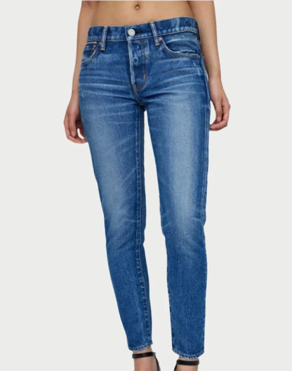 A person wearing high-waisted, slim-fit blue Forestville Tapered Jeans and black heels stands against a plain background. The button-fly Moussy jeans feature subtle fading on the thighs and slight distressing for added style.