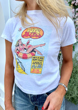 Load image into Gallery viewer, A person is wearing the RE/DONE Pure Bliss Classic Tee, a white T-shirt featuring a vibrant graphic of a woman lounging and drinking a cocktail. The text on the 100% cotton tee reads, &quot;Pure Bliss. She&#39;s in her happy place with a drink in her hand, without a care in the world. Will she ever leave?&quot; They are also paired with blue jeans.