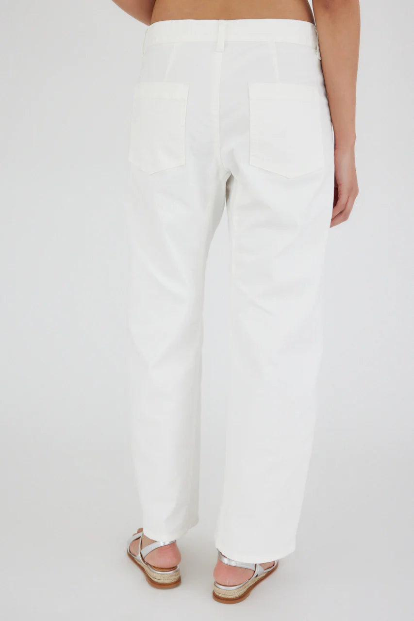 The image shows a person standing with their back to the camera, wearing Rancho Gusset Cargo Pant by Moussy, crafted from non-stretch fabric, with back pockets and brown sandals with white straps. They are standing against a plain light gray background.