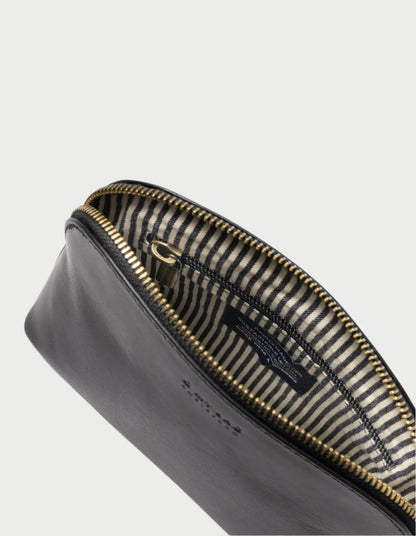 The Cosmetic Bag in Black from O MY BAG is a timeless leather pouch featuring a zippered opening and a striped fabric interior, designed to perfectly accommodate your travel-sized toiletries. The gold-toned zipper enhances its elegance, while an inner label adds a thoughtful touch—making it the perfect gift idea.