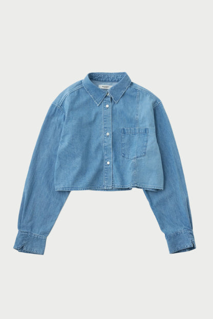 The Moussy Lenfred Cropped Blocking Shirt is a light blue denim cropped shirt with a trendy fit, featuring long sleeves and a front chest pocket. It has a button-down front and classic collar. The slightly faded fabric adds a vintage look, while the button closure cuffs and waist-length hem complete the style.