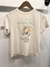 Load image into Gallery viewer, A white, relaxed fit Happys Classic Tee by RE/DONE hanging on a wooden hanger. The shirt features a cartoon dog with long ears sitting in a martini glass. The text above the dog reads &quot;Happy&#39;s Bar,&quot; while the text below says, &quot;We&#39;ll keep your spirits high.&quot; Made from ultra-soft cotton for maximum comfort.