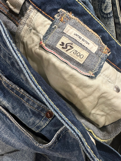 Close-up of a pair of R13's Cuffed Boy Straight jeans showing the inner tag, which reads "Limited Edition 7500." The tag is sewn onto the jeans with visible stitching. The jeans, featuring a classic blue denim with metal buttons and yellow stitching along the seams, are designed in a straight fit style.