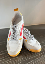 Load image into Gallery viewer, A pair of Oncept Montreal Shoe with white uppers, red accents, and yellow soles is displayed on a wooden surface. The shoes have grey laces and appear brand new. They exude effortless style with their sleek design and modern look.