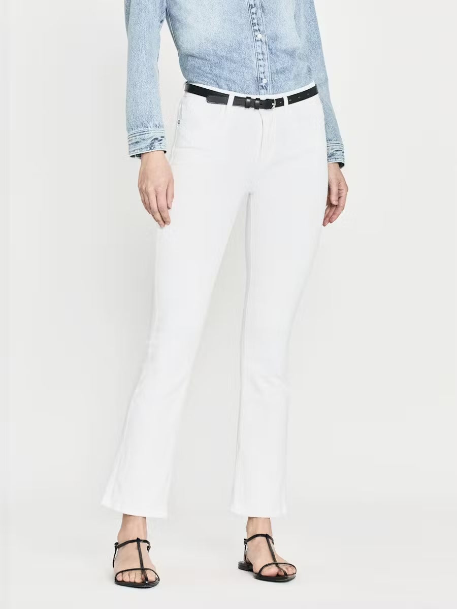 A person sports a light denim shirt and black sandals, paired stylishly with Frame's Le Crop Mini Boot Jeans in White, featuring a contour waistband that enhances a flattering silhouette. The photo is cropped above the shoulders against a plain white background.