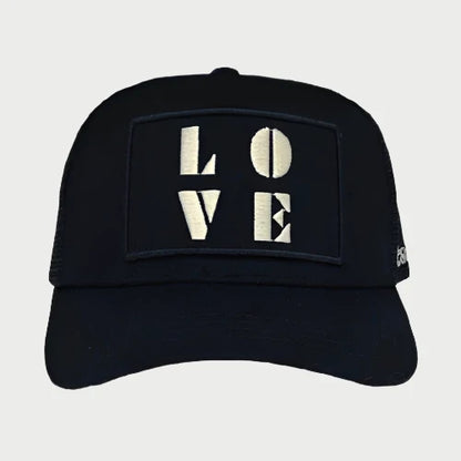 A Soulbyrd LOVE Trucker hat, featuring a black design with the word "LOVE" prominently embroidered in bold white letters on the front.