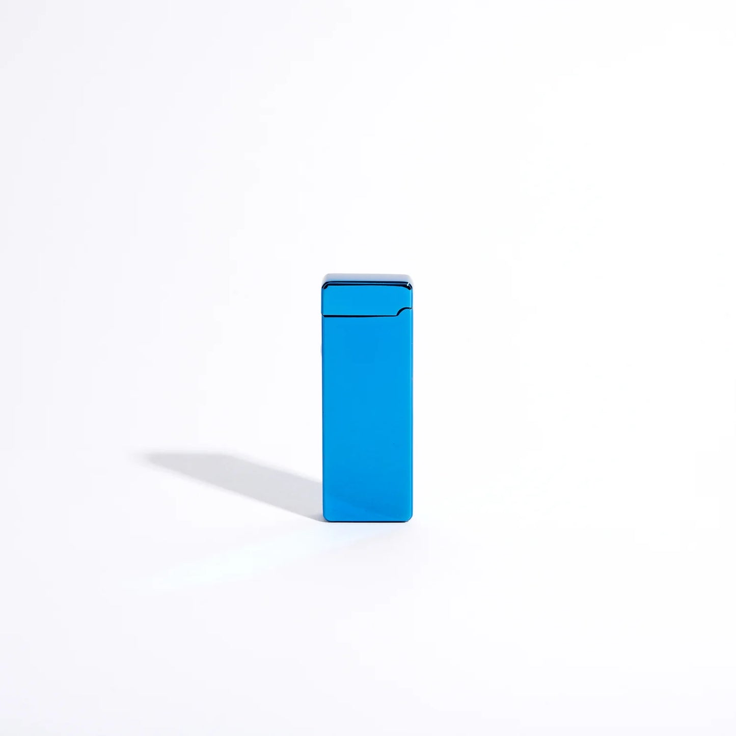 The Pocket USB Lighter by USB Lighter Co features a sleek, rectangular design in blue, standing upright against a minimalist white backdrop. It casts a subtle shadow to the left and showcases a modern, streamlined windproof design that emphasizes simplicity and color contrast. Plus, it offers the convenience of being rechargeable.