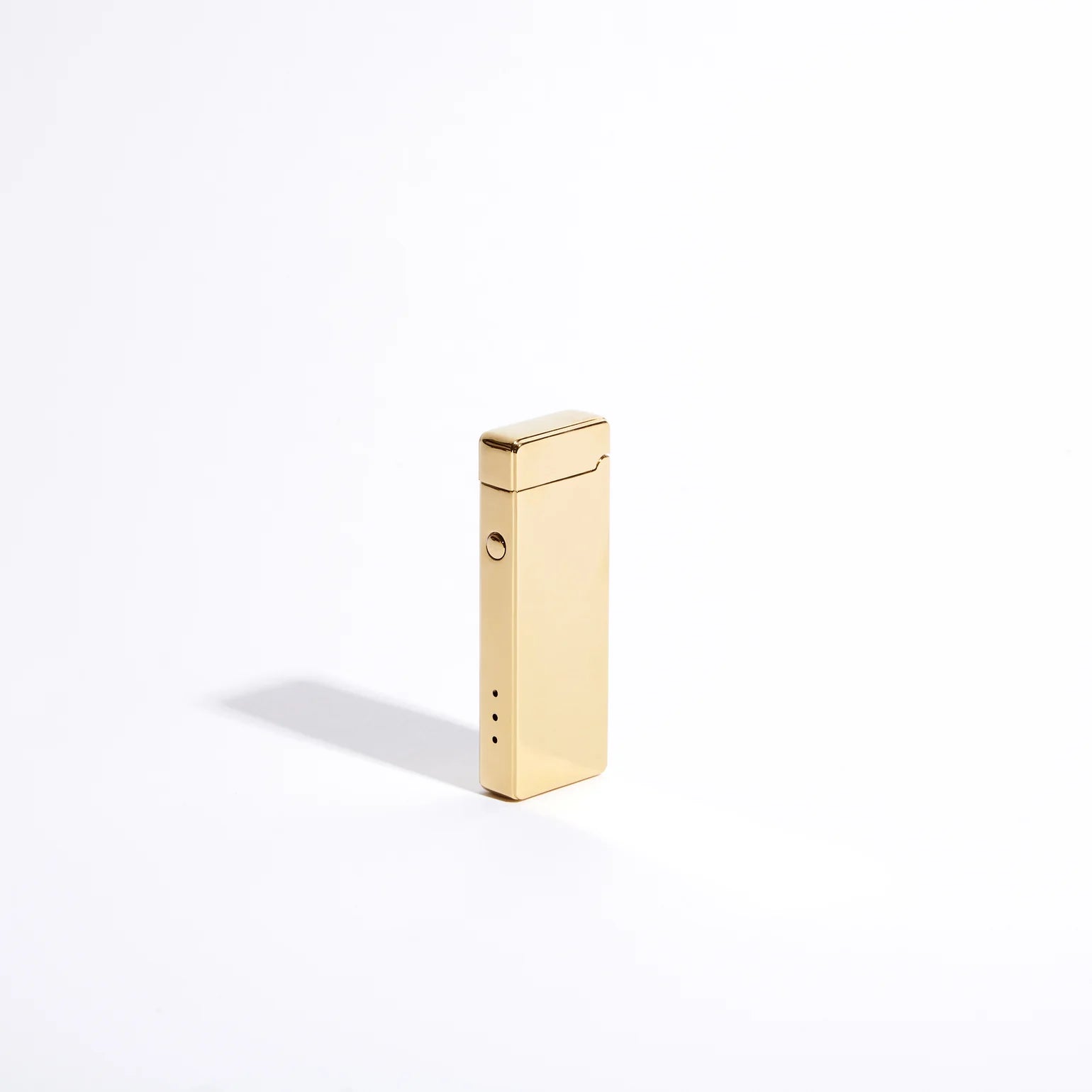 The Pocket USB Lighter by USB Lighter Co, with its sleek gold metal design, stands upright against a plain white background, casting a soft shadow to its left. This rechargeable lighter offers windproof functionality for reliable use in any condition.