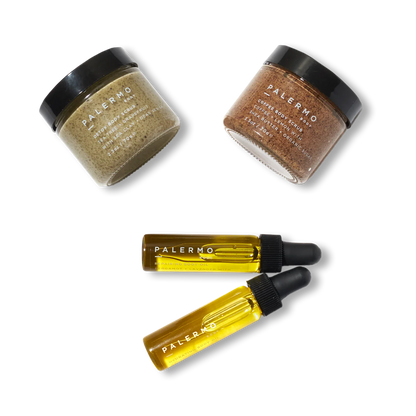 The Body Discovery Kit by Palermo Body includes two glass jars with textured contents and two dropper bottles of yellow liquid, all elegantly placed against a plain black background, ideal for a natural routine.