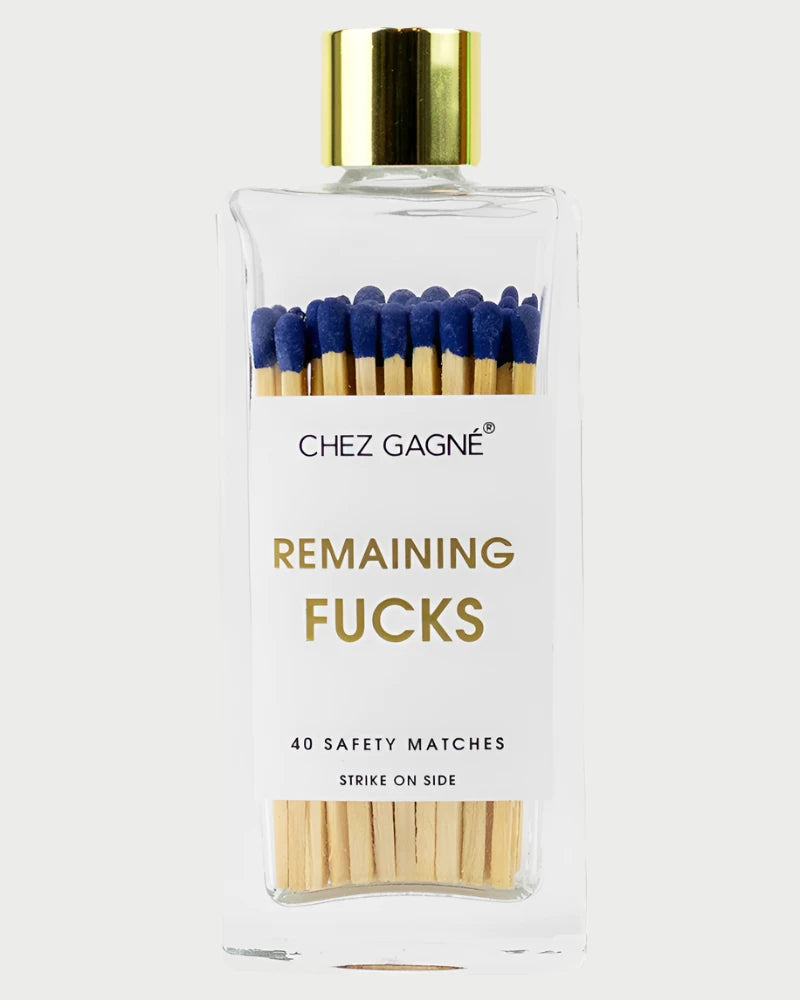 A clear glass jar from Chez Gagné branded as "Colorful Matches" contains 40 wooden matches featuring vibrant blue tips. The text instructs to "Strike on side," and the jar is sealed with a gold cap, labeled as "Remaining Fucks.