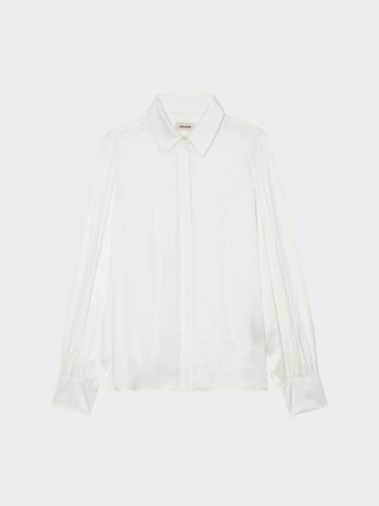 The Trenta Satin Blouse by Zadig & Voltaire is a white piece with a classic collar, long sleeves, and pleated cuff details. Featuring a hidden button placket, its smooth satin fabric offers an elegant and polished look, making it ideal as a transitional wardrobe staple.