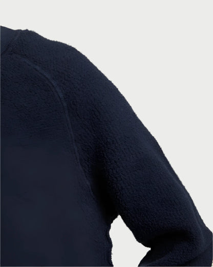 Close-up of the navy blue Ziggy Sweatshirt by perfectwhitetee, highlighting the exposed seam detailing on the shoulder and sleeve, set against a light background.