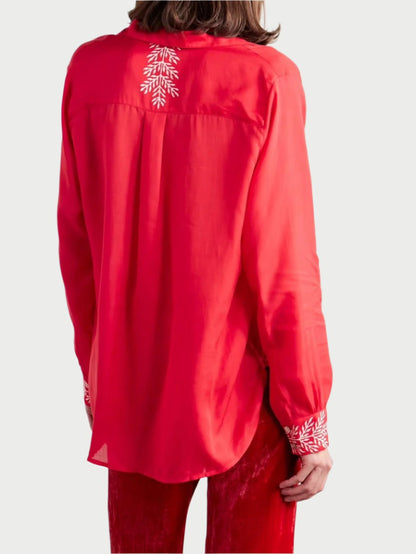 Rear view of a person wearing the Patti Embroidered Shirt in cherry color by Alix of Bohemia. Paired with red velvet pants, the shirt accentuates the person's long brown hair against a plain white background.