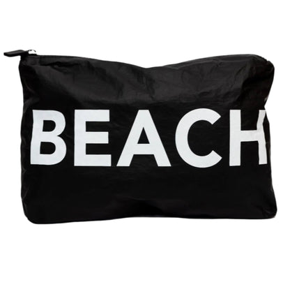 The Printed Pouch- Beach by LOCAL BEACH is a black water-resistant pouch made from 100% Tyvek fabric, featuring the word "BEACH" in large white letters on the front. Ideal for organizing travel toiletries, it stands out beautifully against a plain light gray background.