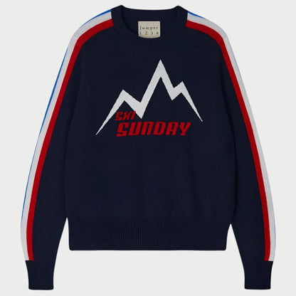 The Ski Sunday Sweater by JUMPER, made from soft wool, features a navy blue base with a stylized white and red mountain design and "CH SUNDAY" on the front. The shoulders of the sleeves are adorned with bold red, white, and blue stripes.