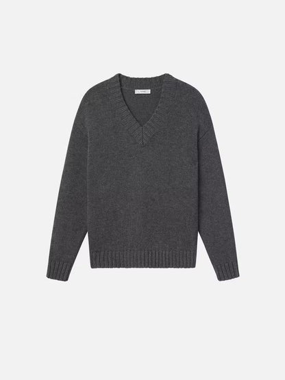 The "Chunky V-neck Sweater" by Frame, presented against a plain white background, showcases a luxurious cashmere-wool blend in dark gray. Ideal for the Fall season, this oversized sweater features ribbed detailing at the neckline, cuffs, and hem.