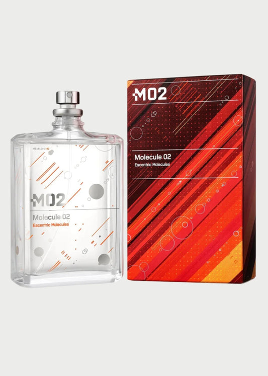 A clear glass bottle of Escentric Molecules- Molecule 02 perfume, infused with Ambroxan, features a minimalist design with geometric patterns and a metallic cap. It stands beside its matching red and orange box displaying the name "Escentric Molecules- Molecule 02" with dynamic line and dot patterns.