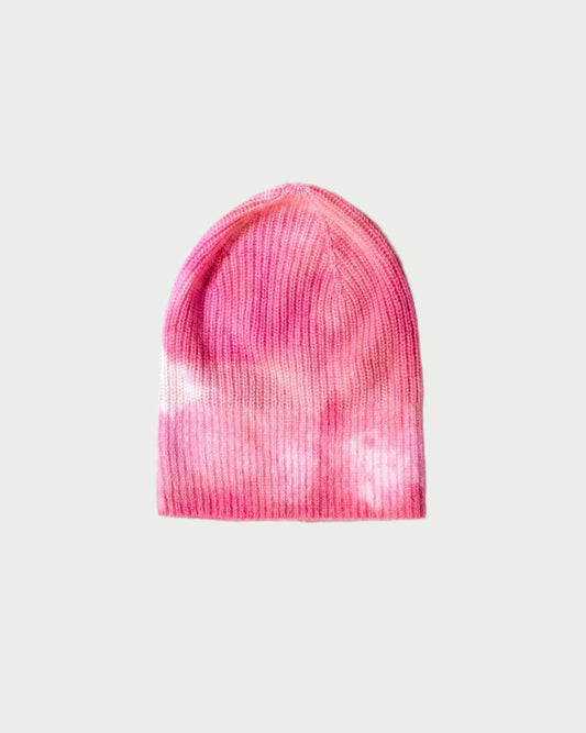 A pink and white Dip Dyed Beanie from MAREA, featuring a ribbed texture made from sustainable cashmere, showcases an artisanal dye process against a plain light background.