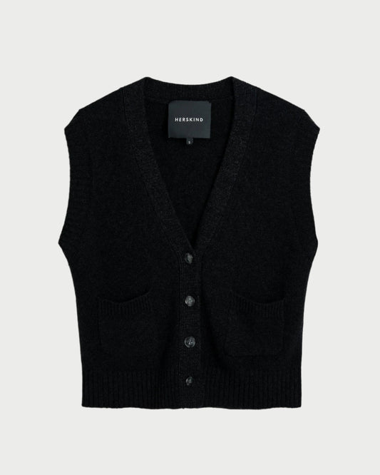 The Herskind Thea Knit Vest is a black, sleeveless button-up vest made from soft wool. It features two small front pockets and serves as an ideal layering piece, elegantly shown on a plain background.