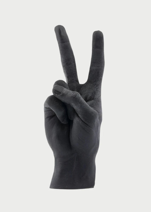 A black, handmade Candle Hand Victory "Peace" by 54° Celsius shaped like a life-sized hand giving a peace sign with two wicks at the fingertips, set against a plain white background.