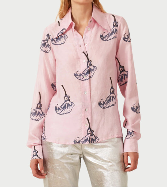 A person is dressed in an Alix of Bohemia's Pink Calla Lily Shirt, adorned with a delicate pink calla lily pattern and dangling flowers. They pair this with shimmering silver pants that glisten with every step.