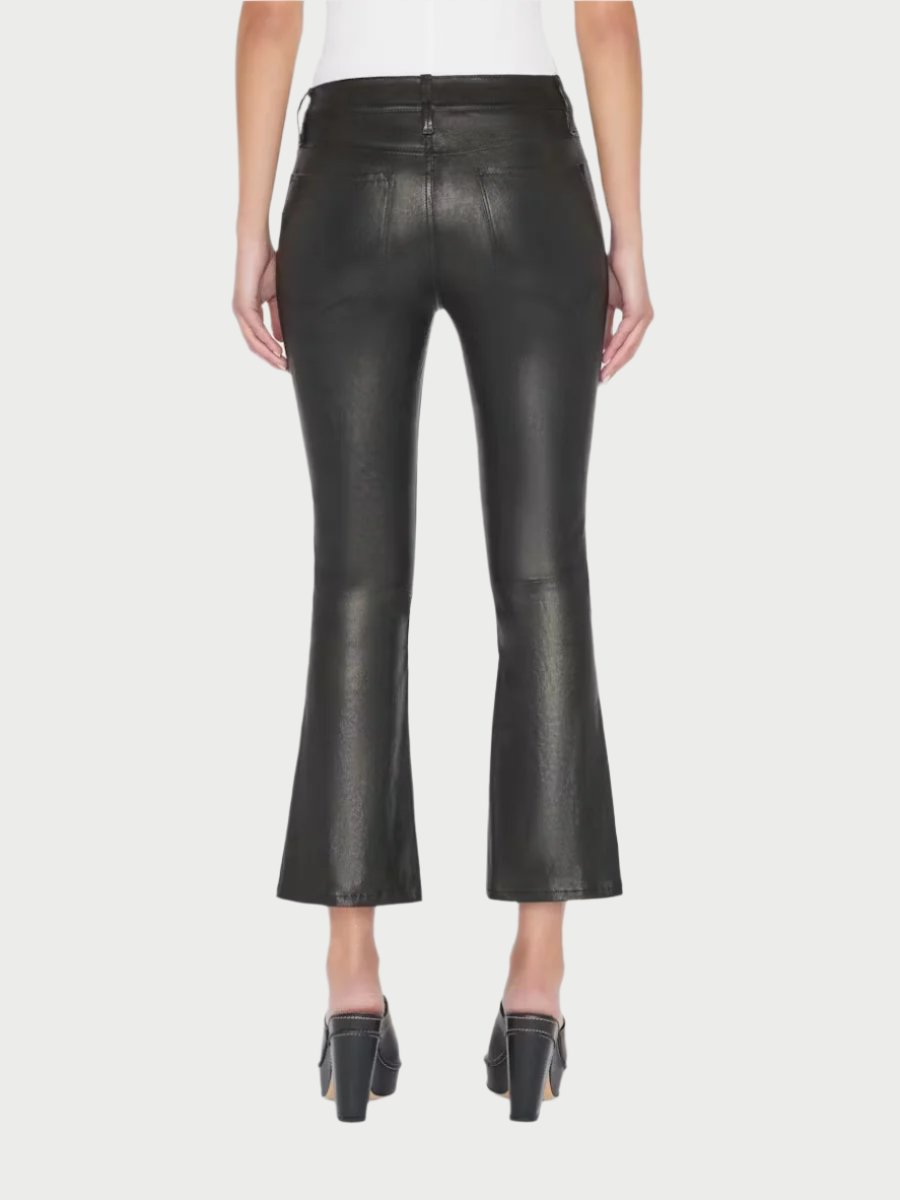 A person is wearing Frame's Le Crop Mini Boot Leather Pants, which feature a high-waisted design, a flared and cropped cut, and visible seams. These wardrobe must-haves are paired with black high-heeled shoes. The person is facing away, showcasing the back view of this versatile styling piece against a plain white background.