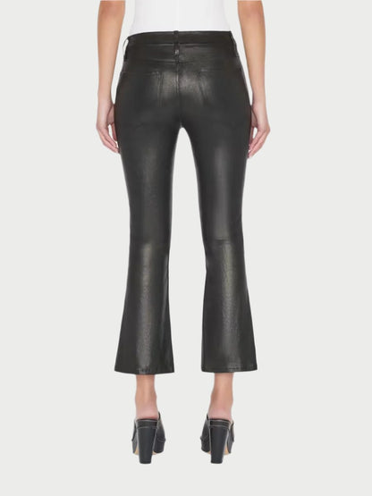 A person is wearing Frame's Le Crop Mini Boot Leather Pants, which feature a high-waisted design, a flared and cropped cut, and visible seams. These wardrobe must-haves are paired with black high-heeled shoes. The person is facing away, showcasing the back view of this versatile styling piece against a plain white background.