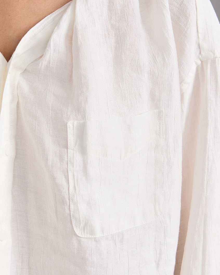 Close-up of R13's Twisted Neck Shirt in white, textured with a left pocket. Made from Japanese crinkle lyocell, it features a relaxed fit and lightweight, breathable fabric.