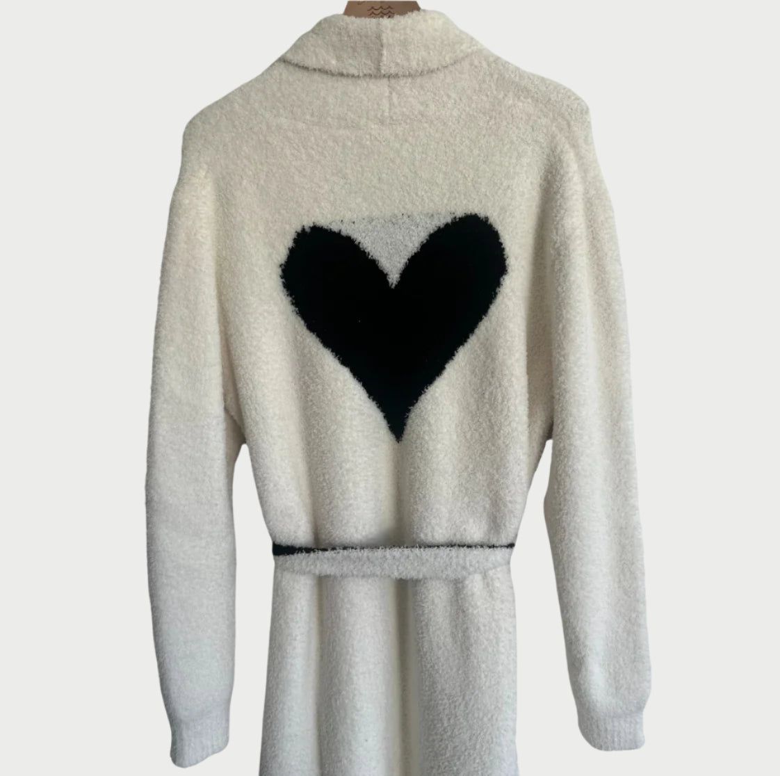 The LOCAL BEACH Love Robe, known as the softest robe, is a long white fuzzy robe with a large black heart design on the back. Its cozy collar is showcased from the rear on a plain light background—a perfect Valentine’s Day gift for that special someone.