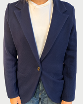 A headless image shows a person in an Archer Cashmere Blazer over a white tee and blue jeans. The buttoned blazer adds elegance.