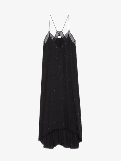 The sleeveless black Risty Dress from Zadig & Voltaire is displayed elegantly on a simple backdrop, showcasing its flowing design, slight high-low hem, and fabric accented with small embellished dots.