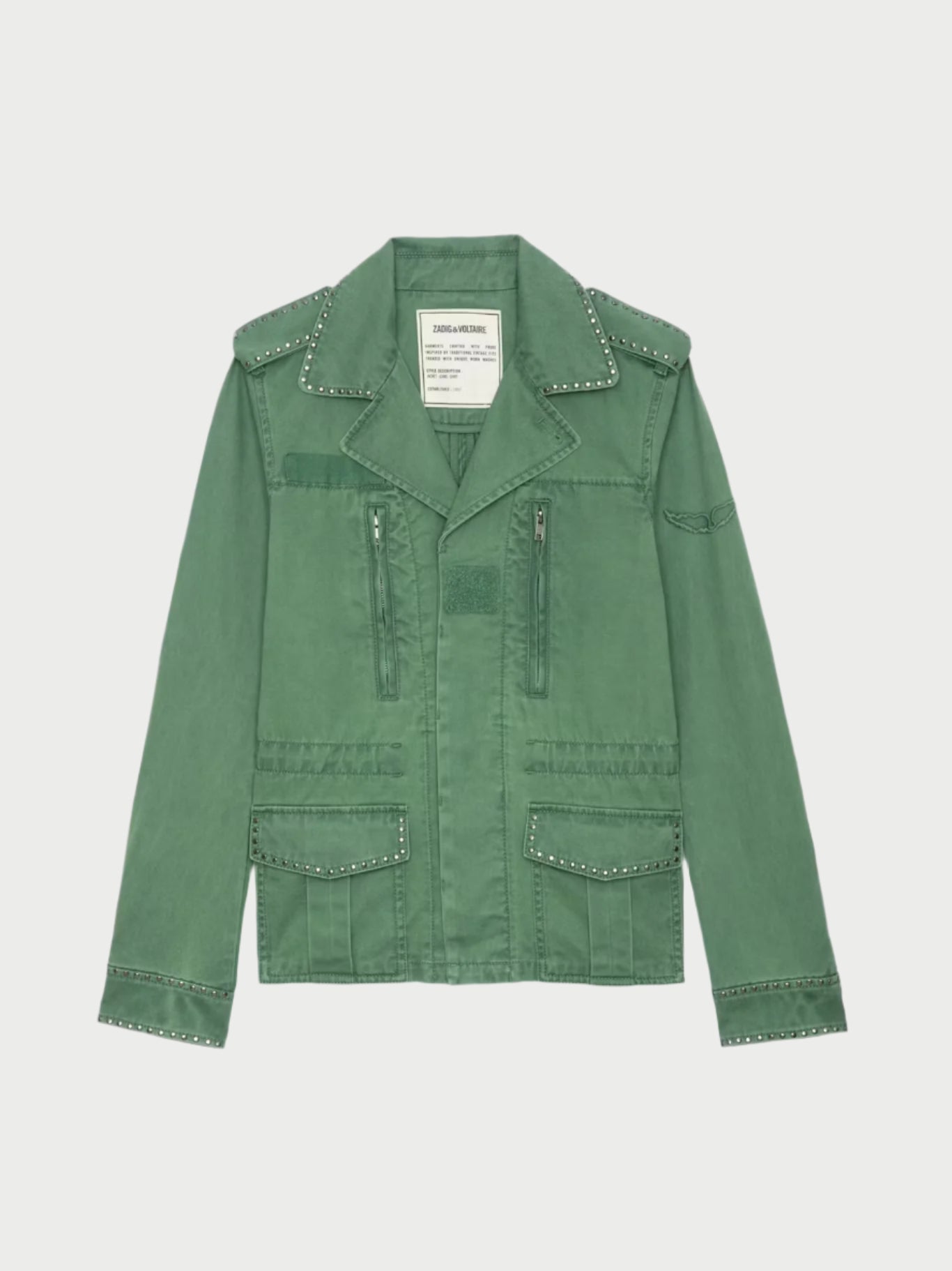 The Klimi Utility Jacket by Zadig & Voltaire is an army green, military-inspired cotton jacket with decorative studs on the lapels, pockets, shoulders, and cuffs. It has a structured design featuring multiple front pockets, zippers, and a label near the collar.