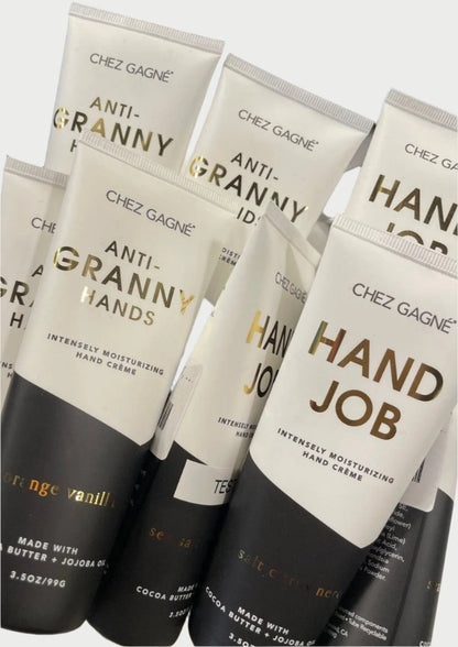 Several tubes of Chez Gagné Hand Creme are displayed, featuring humorous labels like "Anti-Granny Hands" and "Hand Job". These intensely moisturizing hand cremes, enriched with cocoa butter and jojoba oil, come in delightful variations such as "Orange Vanilla" and "Sea Citrus".